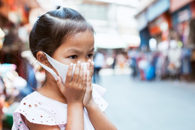 maschera di protezione d&#39;uso della ragazza asiatica del bambino contro inquinamento dello smog dell&#39;aria