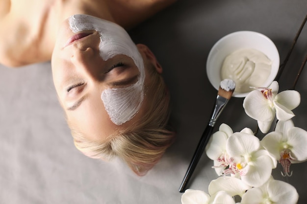 Maschera faccialebella ragazza alla spa estetista donna che applica maschera facciale