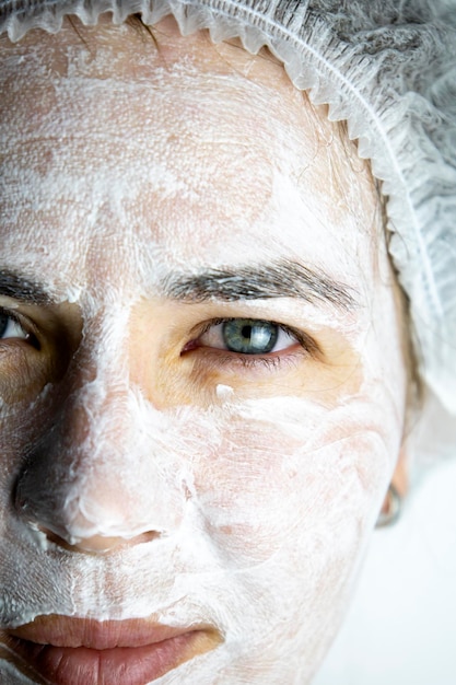 Maschera in crema sul viso della maschera viso ringiovanente della ragazza