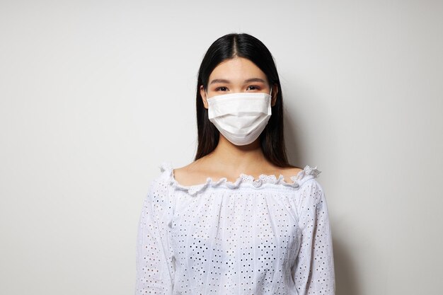 Maschera medica da donna sullo sfondo chiaro di protezione della testa inalterata