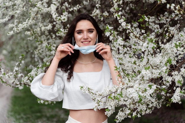 Maschera medica per la protezione contro il coronavirus covid-19. La ragazza si toglie la maschera dal viso a causa della fine della pandemia.