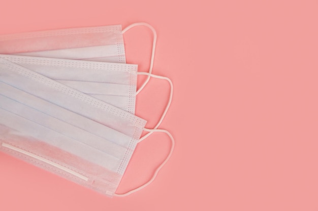 Maschera medica per la protezione contro l'influenza e il coronavirus su uno sfondo rosa prevenzione