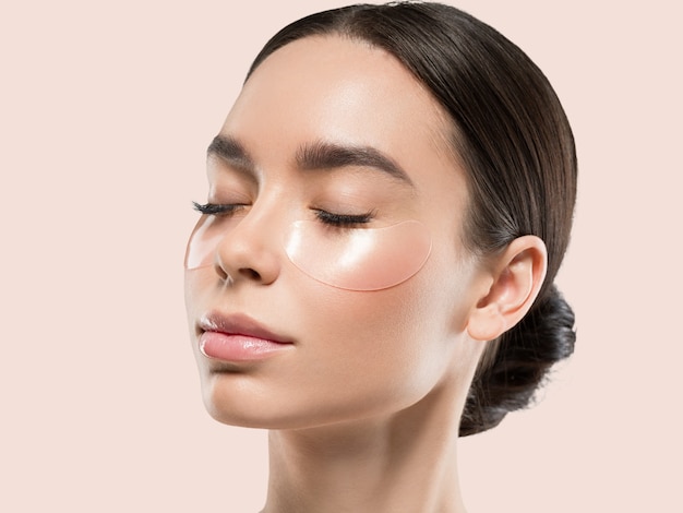 Maschera per gli occhi cosmetico viso donna asiatica. Colore di sfondo. Rosa