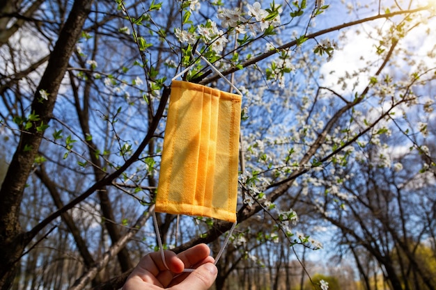 Maschera protettiva contro il virus nella foresta primaverile Epidemia di coronavirusxA