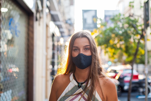 Maschera protettiva da portare all'aperto di bella donna sulla strada