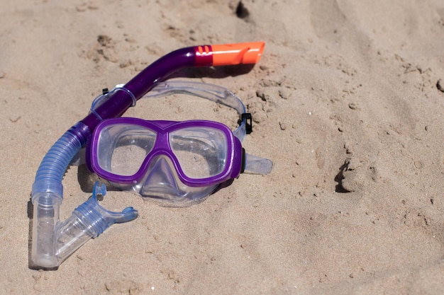 Maschera subacquea per bambini sulla sabbia in spiaggia Copia spazio