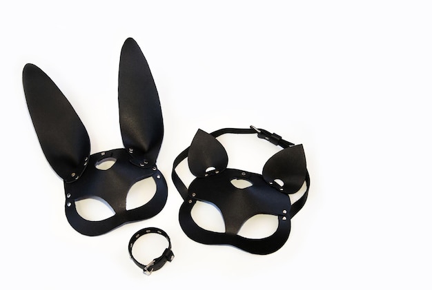 Maschere in pelle di un gatto e un coniglio un braccialetto in pelle su sfondo bianco Carnevale in maschera