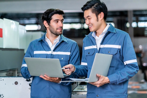 Maschio asiatico caucasico ingegnere professionista che ha una discussione in piedi consultare la macchina in fabbrica due colleghi esperti di brainstorming che spiegano e risolve il processo della macchina di funzionamento cnc