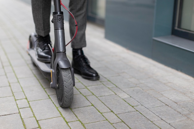 Maschio casuale in sella al suo scooter elettrico