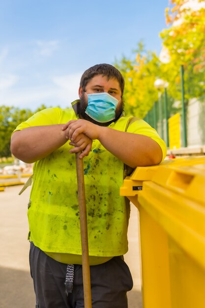 maschio che lavora per un'impresa di pulizie con maschera