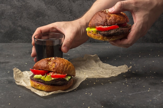 Maschio che tiene hamburger di manzo alla griglia appena preparato