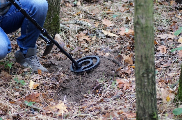 Maschio che usa un metal detector e cerca tesori sepolti