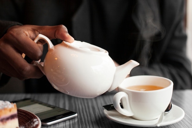 Maschio del primo piano che gode di una tazza di tè