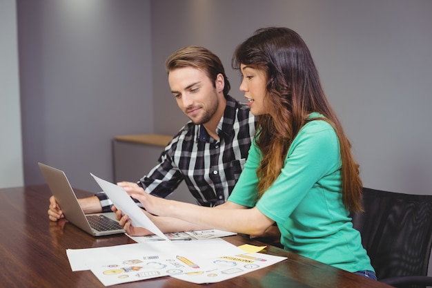 Maschio e grafici che lavorano insieme nella sala conferenze