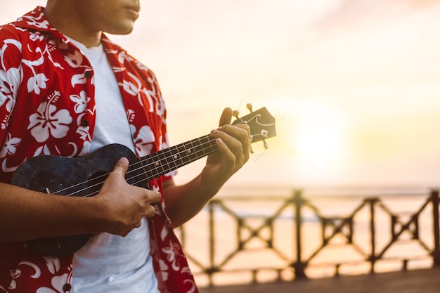 Maschio ispanico che suona l'ukulele