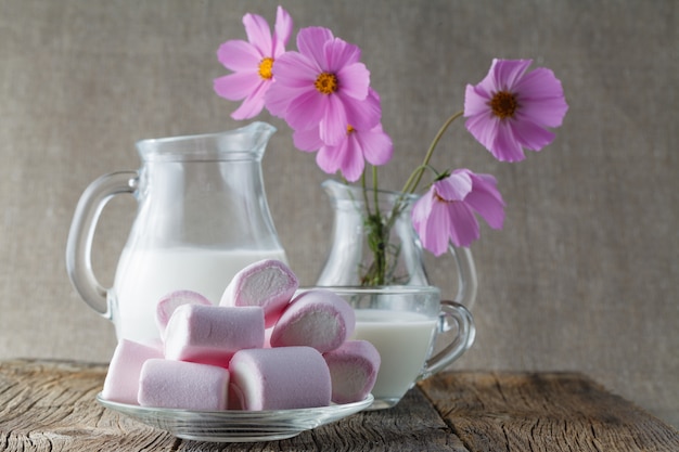 Mashmallow colorato con latte sulla tavola di legno