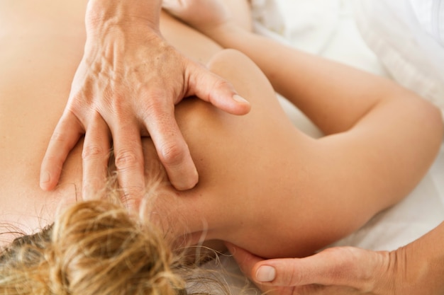 Massaggi a una donna sul collo su una barella medica