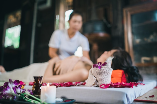 Massaggi e spa trattamento rilassante della sindrome dell'ufficio massaggio tradizionale tailandese stile Asain massaggiatrice femminile che fa massaggio trattamento mal di schiena dolore al braccio e stress per donna d'ufficio stanca dal lavoro