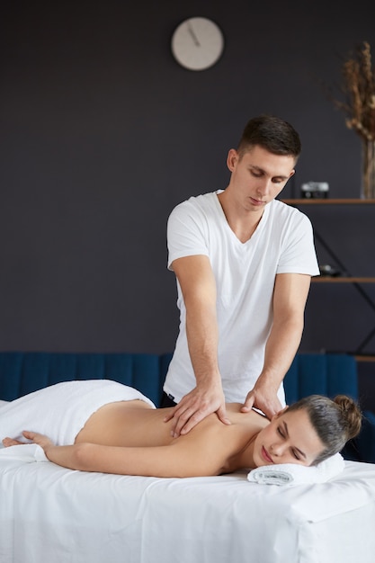 Massaggiatore professionista sta curando una paziente in appartamento.