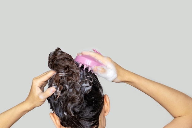 massaggiatrice del cuoio capelluto stimolante la crescita dei capelli utilizzando una spazzola per shampoo massaggiante rosa per il cuoio capelluto con silicone