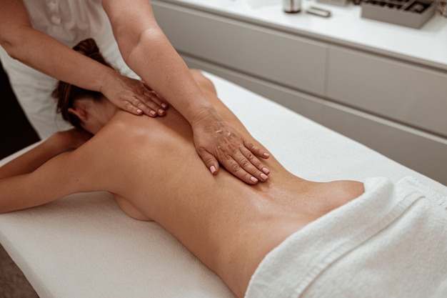 Massaggiatrice professionale che massaggia la schiena nel salone della spa