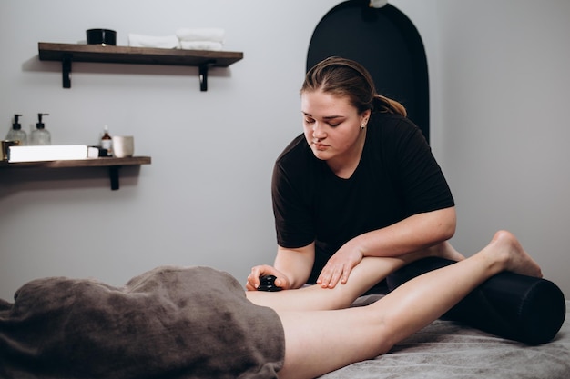 Massaggio per i piedi Nel salone di massaggio Estetista asiatica femminile che passa l'aspirapolvere con la macchina al salone