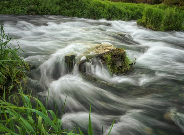 Massi nel riffle d'acqua del fiume di montagna