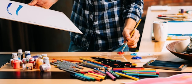 Master class di belle arti Spazio di lavoro creativo Matite colorate sul tavolo Colpo ritagliato di pittore mancino
