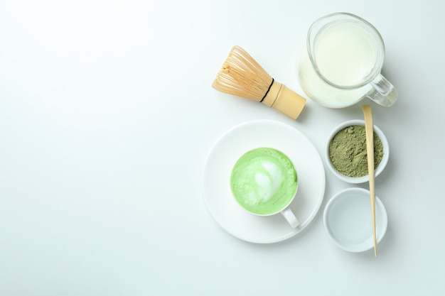 Matcha latte e accessori per fare su sfondo bianco