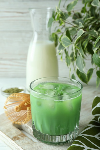 Matcha latte e accessori per fare sul tavolo di legno bianco