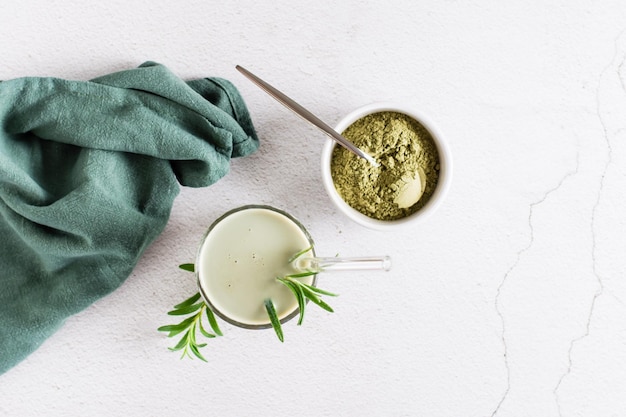 Matcha latte in un bicchiere e polvere in una ciotola sul tavolo Bevanda alla moda fatta in casa Vista dall'alto