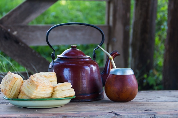 Mate e bollitore con un piatto di biscotti salati argentini e infuso di yerba mate