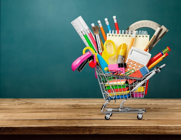 Materiale scolastico colorato nel carrello della spesa