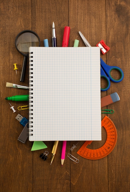 Materiale scolastico e taccuino su legno