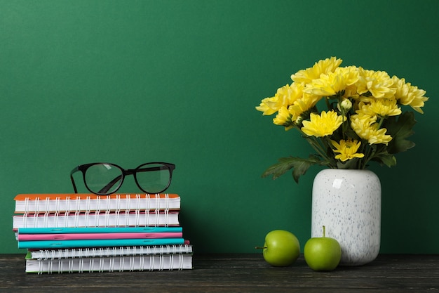 Materiale scolastico e vaso con fiori, spazio per il testo