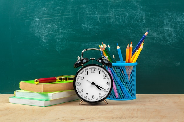 Materiale scolastico. Scrittura di utensili e sveglia. Tempo di studiare