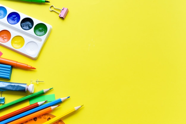 Materiale scolastico su uno sfondo giallo