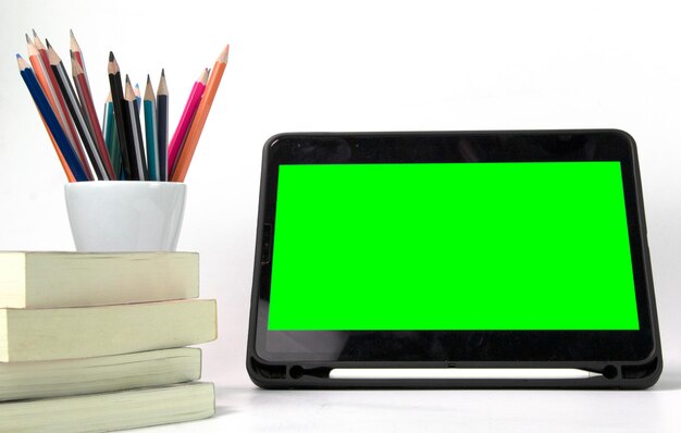 Materiali didattici nella scatola con schermo verde dell'iPad e libri isolati su sfondo bianco Modelli concettuali di ritorno a scuola