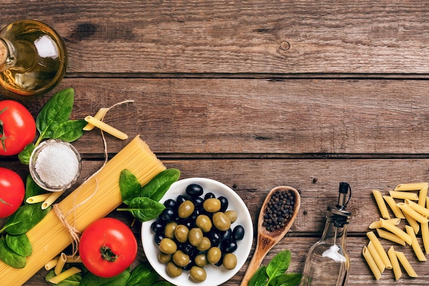 Materie prime per la preparazione della pasta italiana spaghetti basilico pomodori olive e olio d'oliva o