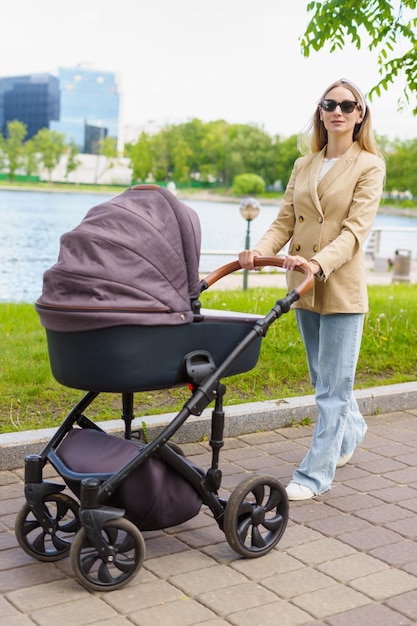 Maternità che cammina nel passeggino del parco