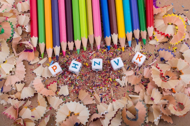 Matite colorate e cubetti di lettere su trucioli di matita