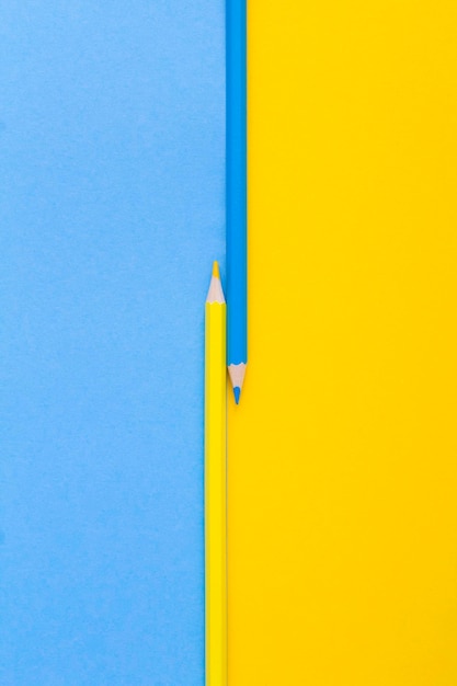 Matite gialle e blu sullo sfondo colorato Vista dall'alto Spazio di copia Posizione verticale