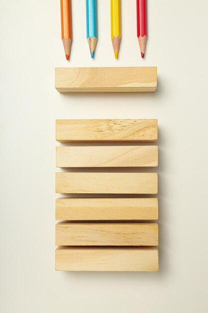 Matite multicolori con blocchi di legno su sfondo bianco Concetto di giornata mondiale dell'autismo