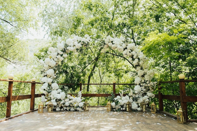 Matrimonio ad arco a tutto tondo decorato con verde e fiori bianchi