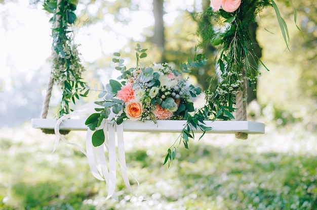 Matrimonio bouquet di rose beige e rosa all&#39;aperto sull&#39;altalena decorata