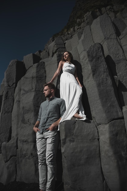 Matrimonio destinazione Islanda. Una coppia di sposi sta camminando lungo la spiaggia nera di Vic.