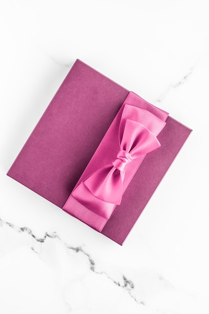 Matrimonio di compleanno e concetto di branding femminile scatola regalo rosa con fiocco di seta su sfondo di marmo regalo per baby shower ragazza e regalo di moda glamour per design artistico flatlay di vacanza di marca di bellezza di lusso