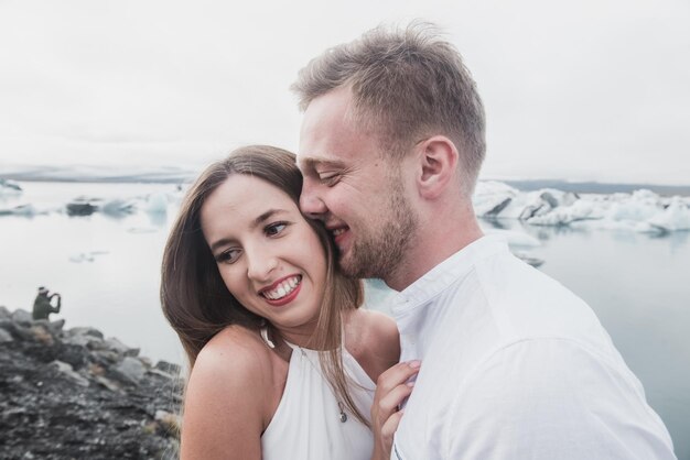 Matrimonio in Islanda. Un ragazzo e una ragazza con un vestito bianco si abbracciano mentre sono in piedi su un ghiaccio blu