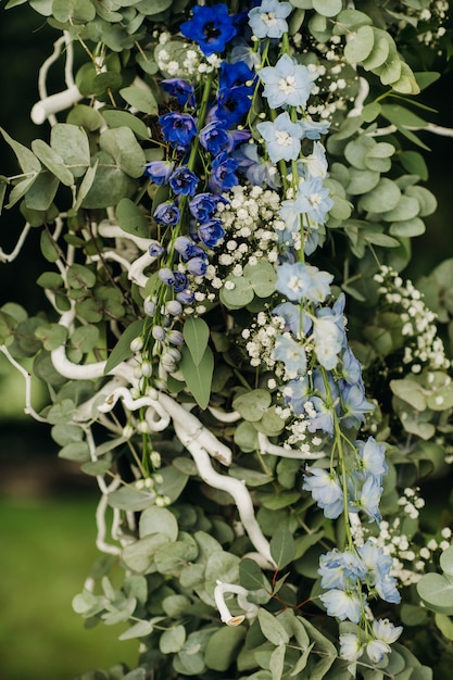 Matrimonio in strada sul prato verde. Decorazioni con archi di fiori freschi per la cerimonia.