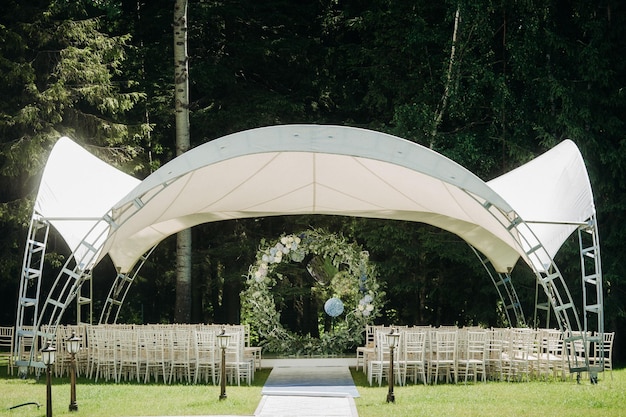 Matrimonio in strada sul prato verdeDecorare con archi di fiori freschi per la cerimonia